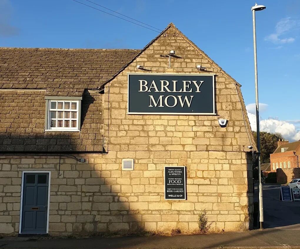 The stone gable of The Barley Mow on Main Street, Hartford, with the Barley Mow sign in evening sun